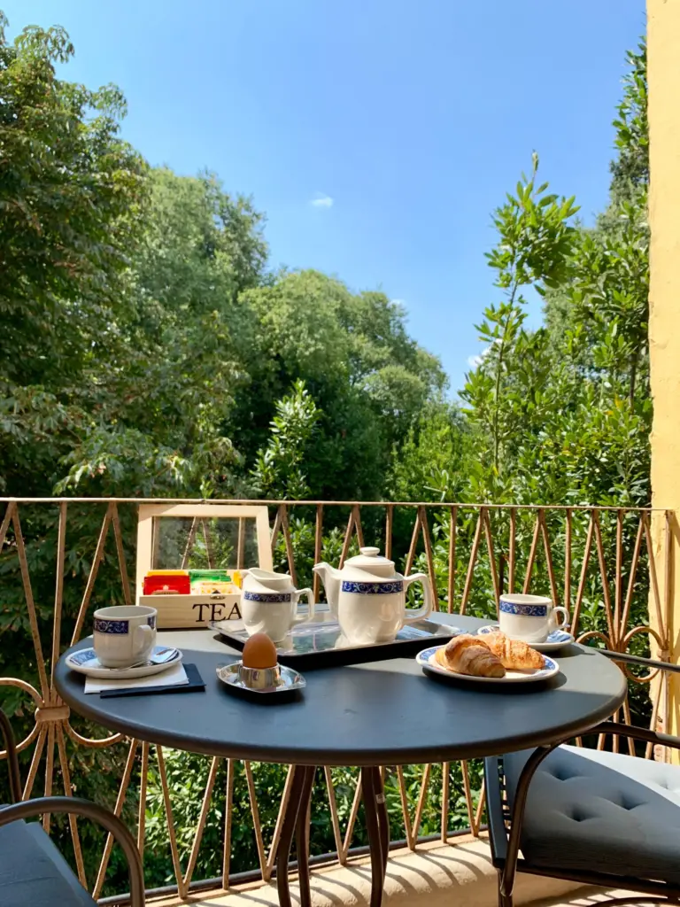 Coffee and croissants on a balcony table among the trees