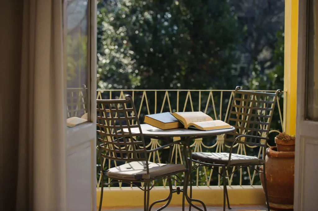 Balcony with a small table, two chairs and a book, open to the garden