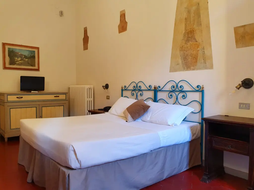 Double room with a blue iron bed and painted wall decorations