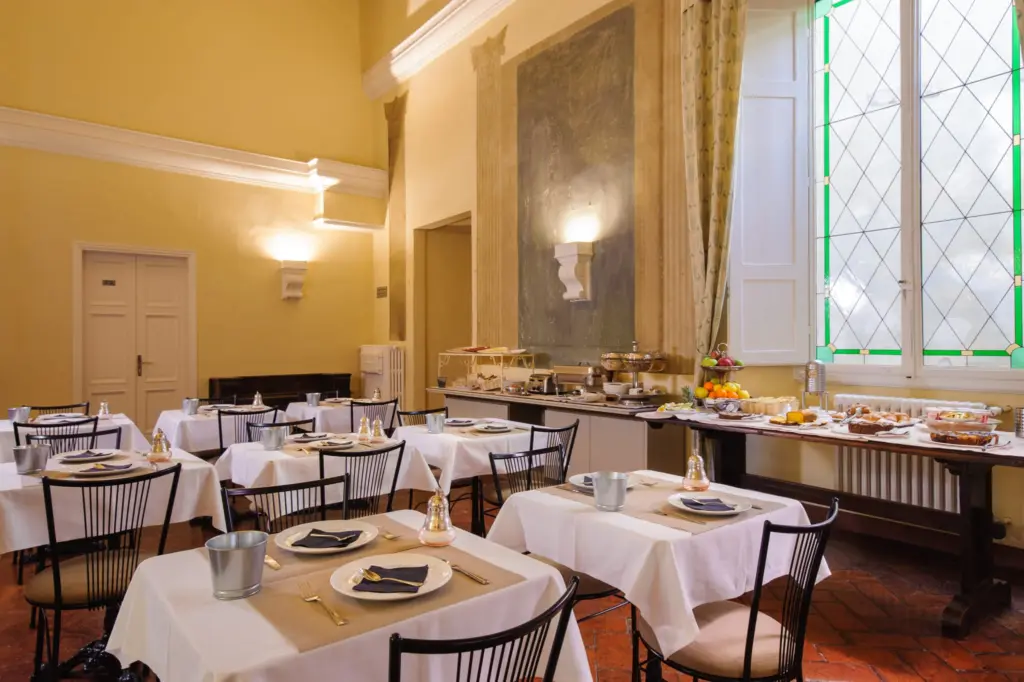 Breakfast room with laid tables and tall windows