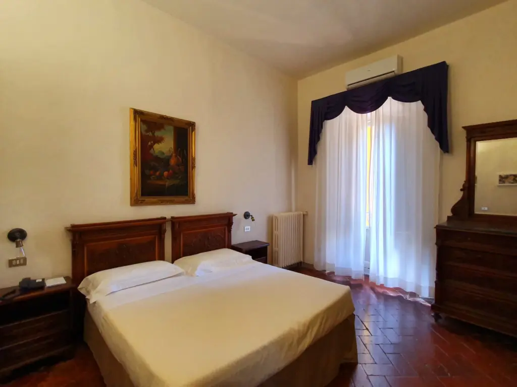 Double room with a wooden headboard and blue curtains