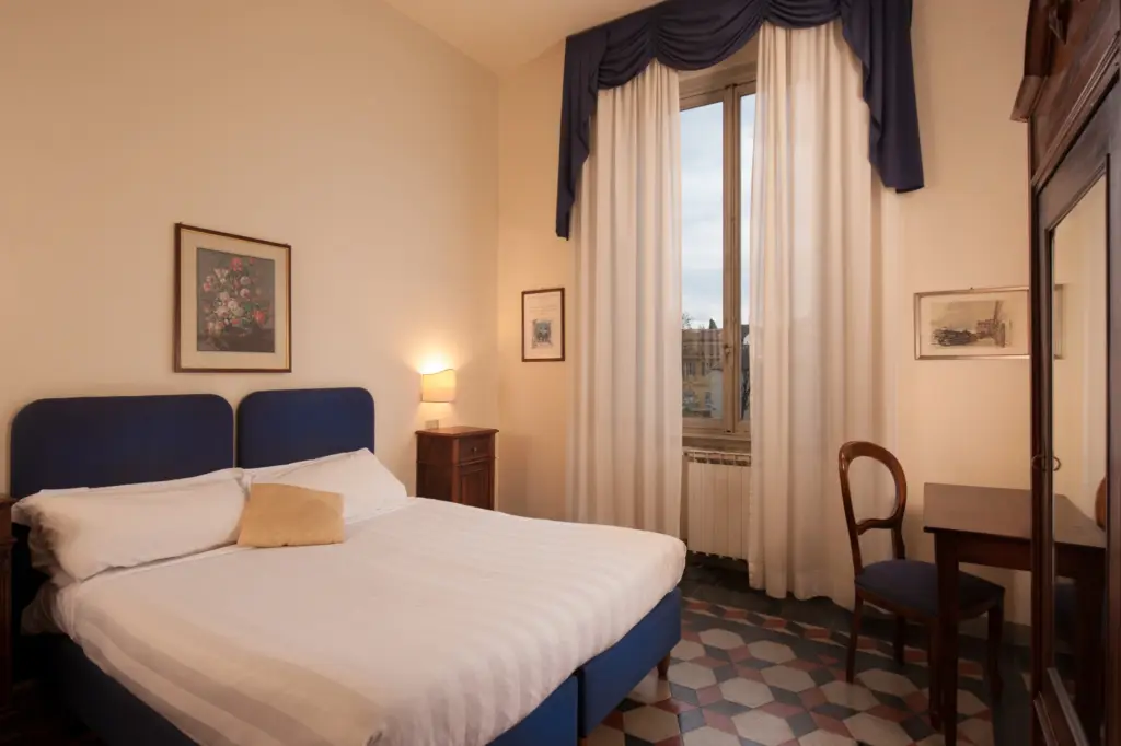 Double room with a blue headboard and a writing desk