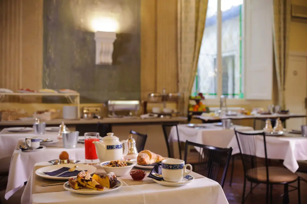 Buffet della colazione con dolci, frutta e tavoli apparecchiati