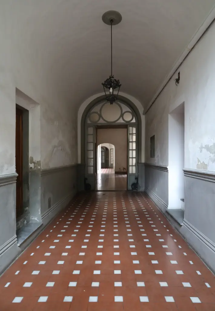 Entrance hall with a terracotta and white floor and a lantern